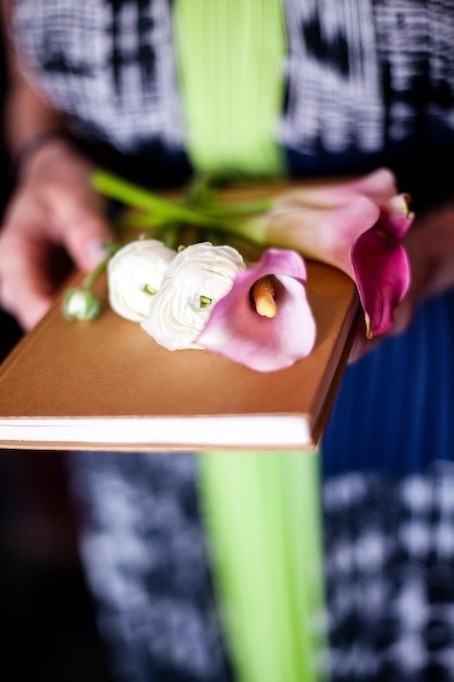 Foto close-up van vrouw met boek en bloemen