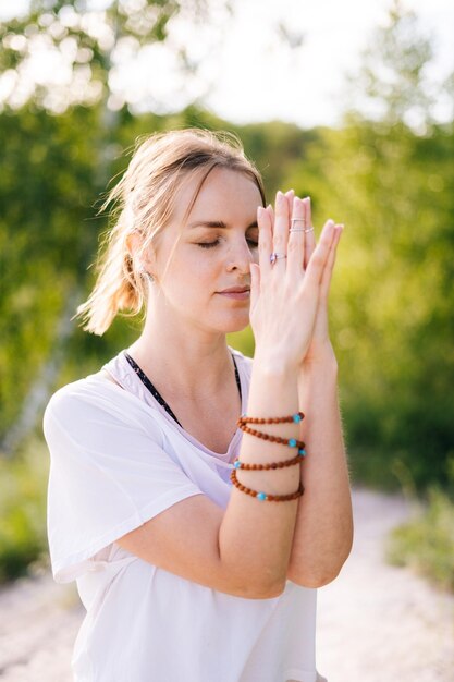Close-up van vrouw met emotie van sereniteit en rust die Namaste-gebaar uitvoert