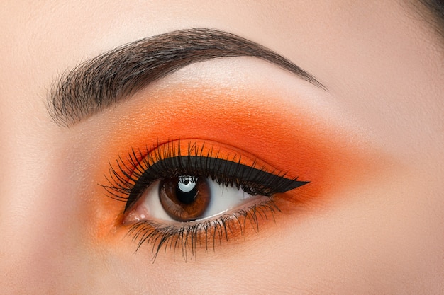 Close up van vrouw met mooie oranje smokey eyes make-up