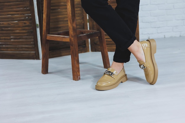 Close-up van vrouwelijke benen in zwarte jeans in stijlvolle lederen beige schoenen Modieuze vrouw in nieuwe loafers Moderne seizoenscollectie van stijlvolle schoenen Damesmode