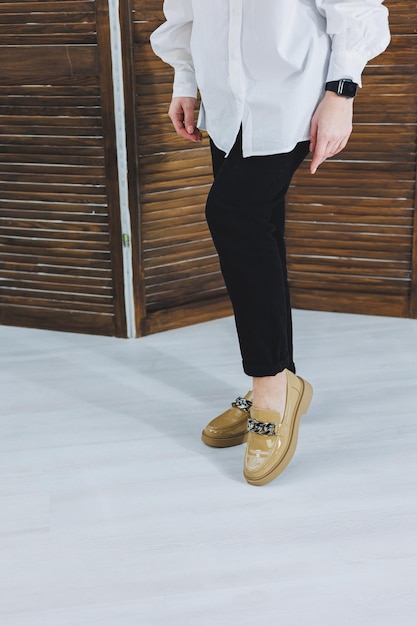 Close-up van vrouwelijke benen in zwarte jeans in stijlvolle lederen beige schoenen Modieuze vrouw in nieuwe loafers Moderne seizoenscollectie van stijlvolle schoenen Damesmode