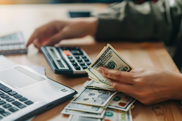 Close-up van vrouwelijke hand die geld telt met rekenmachine en huis op tafel