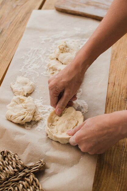 Close-up van vrouwelijke handen beeldhouwen van deeg. bakkerij- en banketbakkersconcept