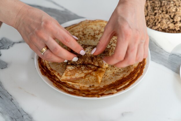 Close-up van vrouwelijke handen die een loempia verpakken