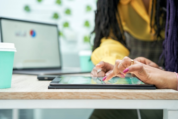 Foto close-up van vrouwelijke handen met behulp van een tablet op kantoor