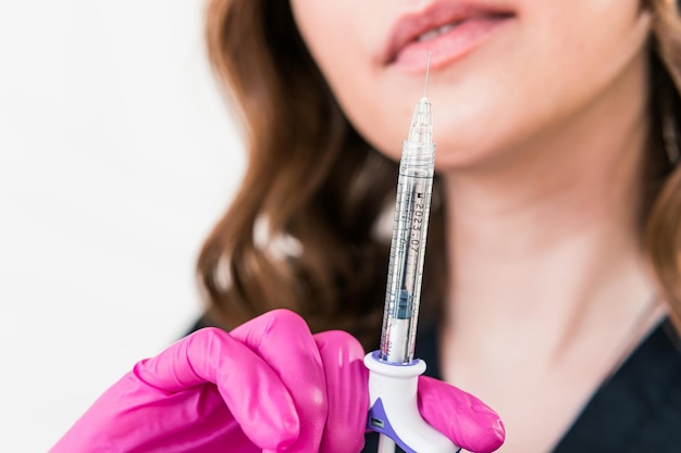 Close-up van vrouwelijke schoonheidsspecialiste arts die spuit met schoonheidsinjecties vasthoudt