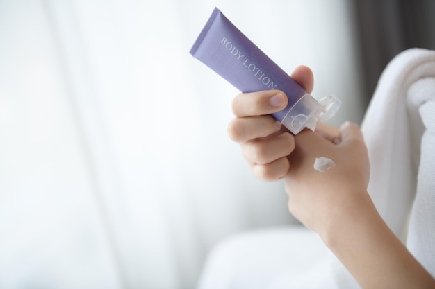 Close-up van vrouwen die bodylotioncrème bij de hand aanbrengen