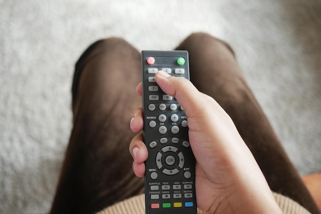 Close-up van vrouwen die de tv-afstandsbediening vasthouden