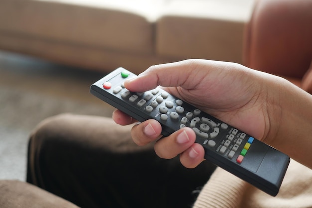 Close-up van vrouwen die de tv-afstandsbediening vasthouden