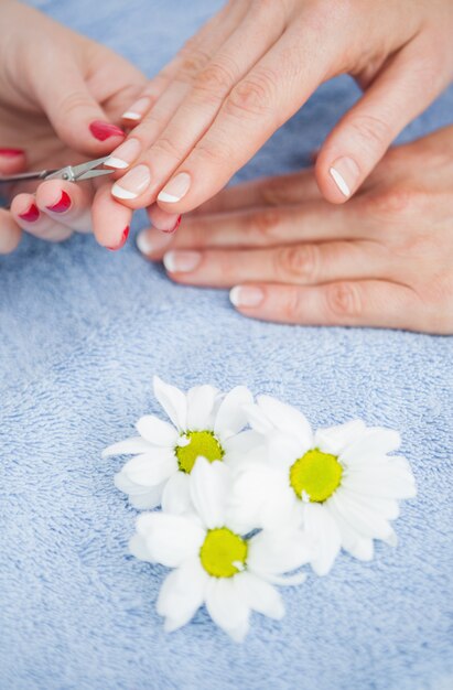 Close-up van vrouwen scherpe vingernagel met schaar bij spijkersalon