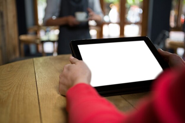 Foto close-up van vrouwenhand die digitale tablet met leeg scherm in koffie gebruikt