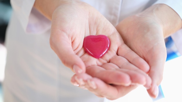 Close-up van vrouwenhanden die helder rood glashart houden van liefde en gelukkige valentijnskaartenvakantie