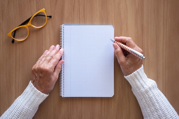 Close-up van vrouwenhanden met pen die op notitieboekje schrijven