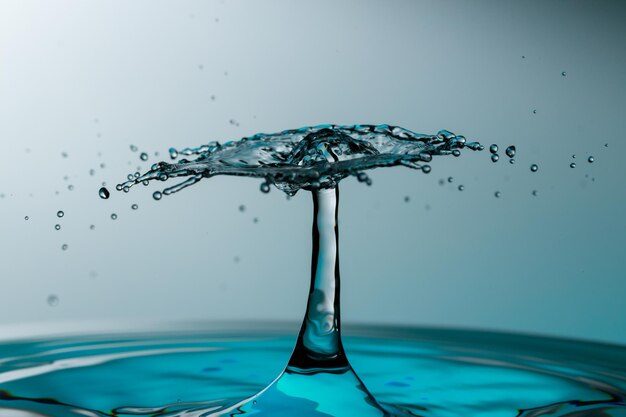 Foto close-up van water spetteren tegen blauwe achtergrond