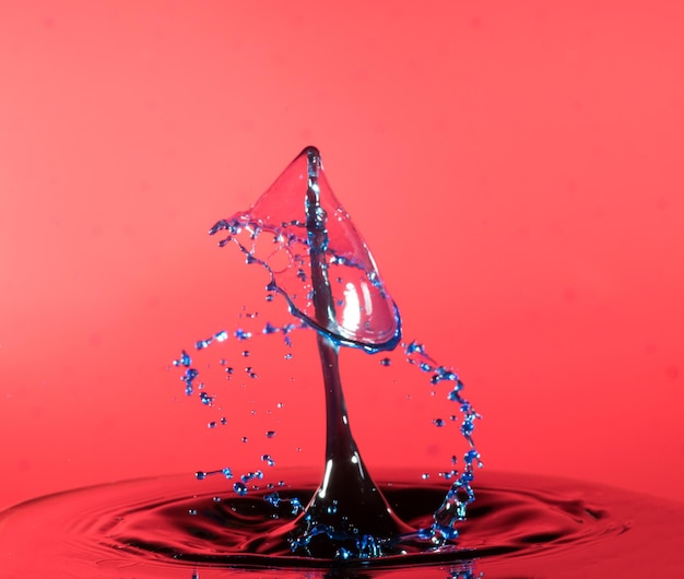 Close-up van water spetteren tegen rode achtergrond