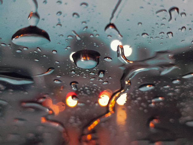 Close-up van waterdruppels op de voorruit van een auto