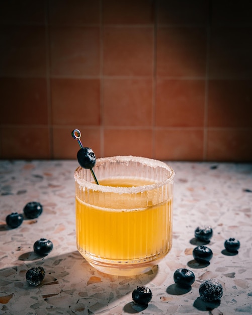 Close-up van whisky zure cocktail in glas met bosbessen op stenen toonbank