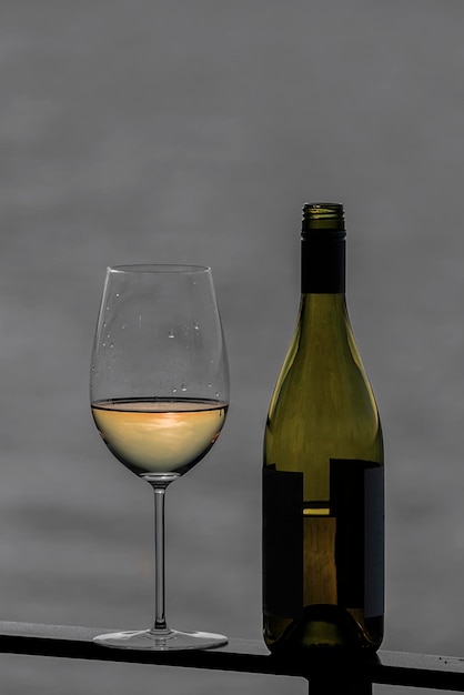 Close-up van wijnglas met fles op reling