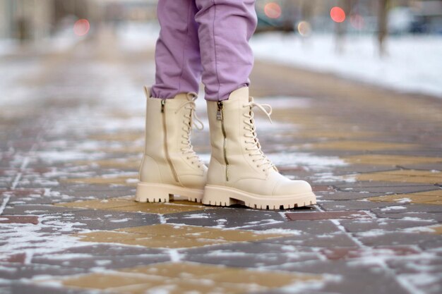 Close-up van witte vrouwelijke laarzen op sneeuw op winterdag vrouw lopen Selectieve focus