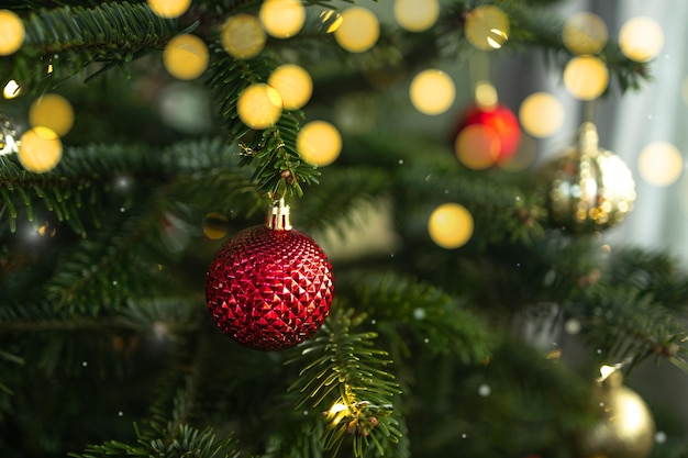 Foto close-up van xmasballen op kerstboom bokeh kralen op de achtergrond nieuwjaarsconcept hoog