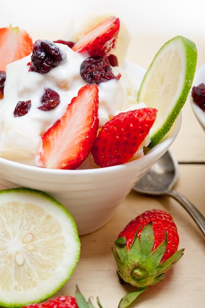 Foto close-up van yoghurt met fruit in een container op tafel