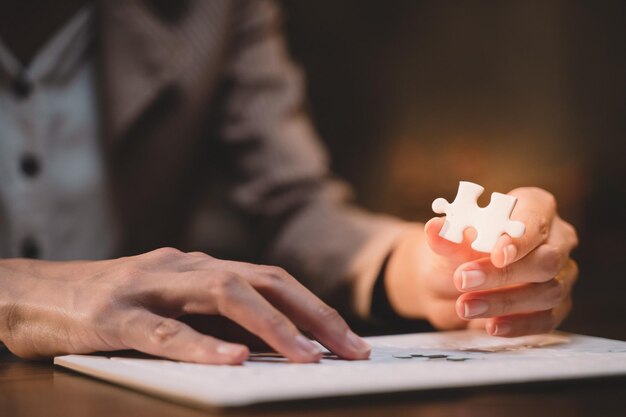 Foto close-up van zakelijke handen die puzzelsucces en doelrealisatie verbinden de laatste puzzel is de link van alle stukken strategische planning of een oplossing voor het management