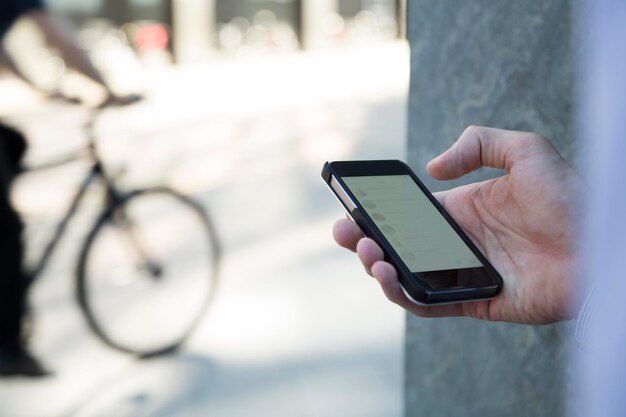 Close-up van zakenman die mobiele telefoon vasthoudt