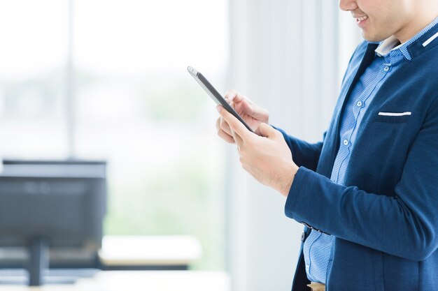 Close-up van zakenman het werken met handsmartphone in het bureau