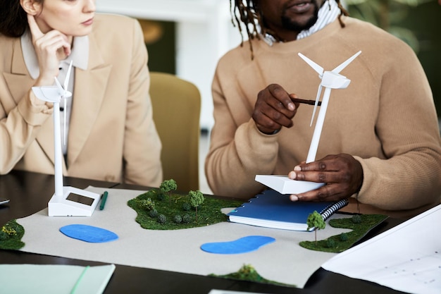 Close-up van zakenmensen die energieproject bespreken aan tafel tijdens meeting