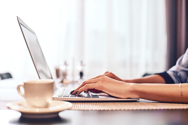 Close up van zakenvrouwen handen typen met behulp van laptop in het café