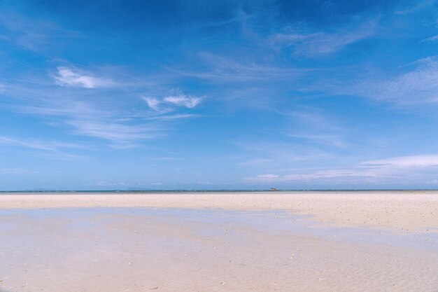 Foto close-up van zand op het strand en blauwe zomerhemel panoramisch strandlandschap leeg tropisch strand en zeelandschap oranje en gouden zonsondergang hemel zacht zand kalmte rustige ontspannende zonlicht zomer sfeer