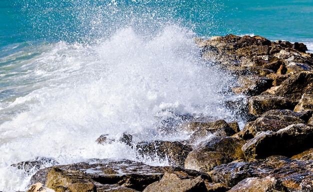 Close-up van zeegolven die breken op de rotsen van het strand van Vilanova y la Geltru.