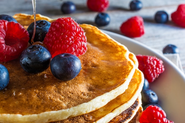 Close up van zelfgemaakte pannenkoeken met verse bessen en honing