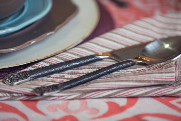 Foto close-up van zilverwerk op servet aan de eettafel