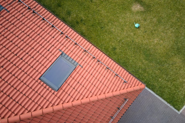 Close-up van zolderraam op dak van huis bedekt met keramische dakspanen Betegelde bekleding van gebouw