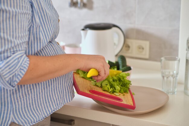 Close-up van zwangere vrouw met mes op keuken