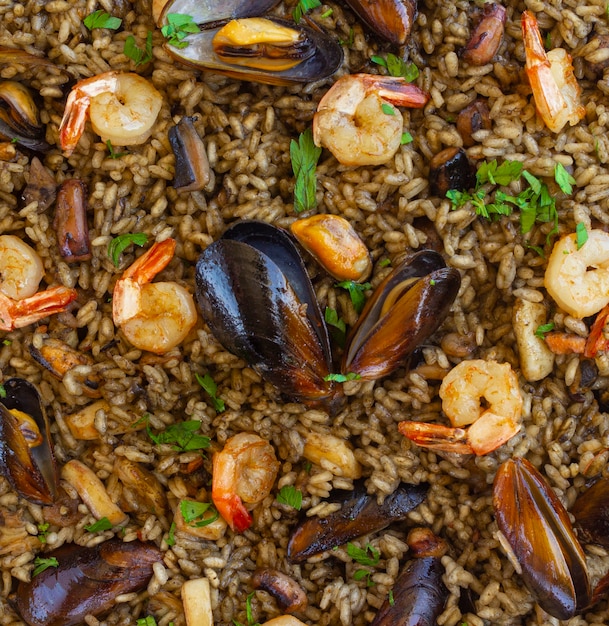 Close-up van zwarte paella met zeevruchten