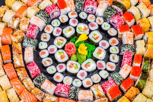 Close up of a variety of sushi rolls in different colors and flavors.