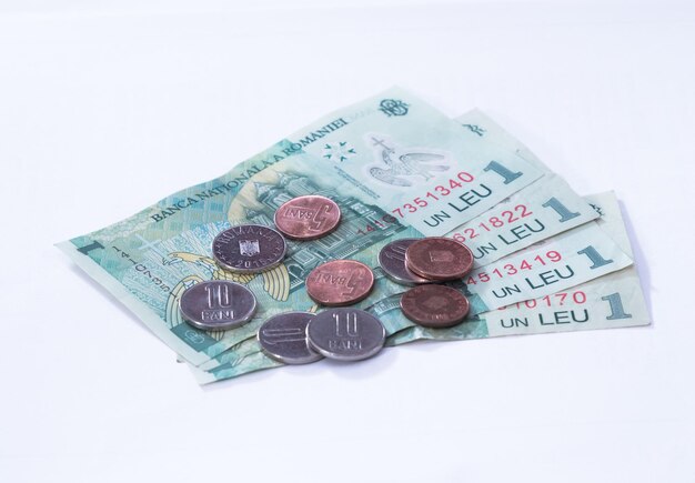 Foto close-up di varie monete con carta moneta su sfondo bianco