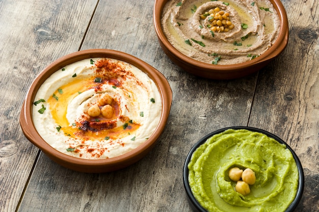 Close up on various hummus in bowls with chickpeas and lentils