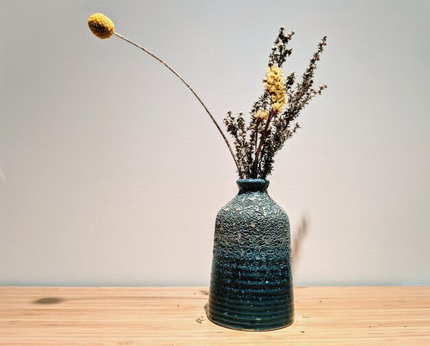 Close-up of vase on table against wall