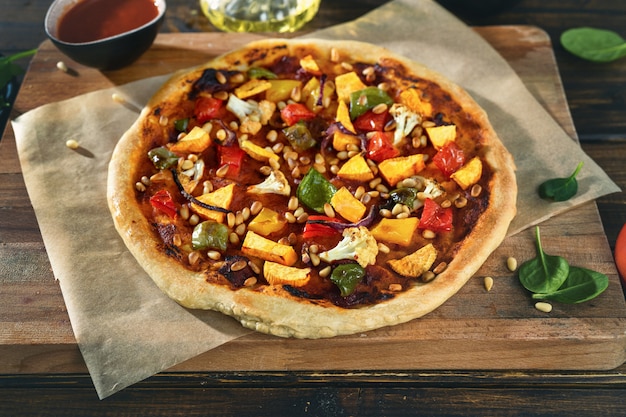 野菜、ペスト、松の実のビーガン自家製ピザのクローズアップ