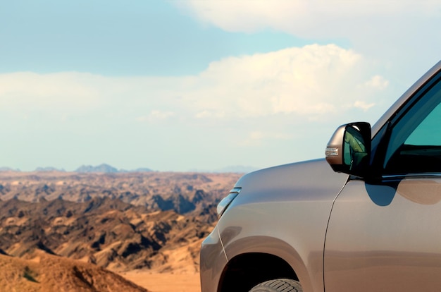 Close-up of a vehicle in the sand before a cliff.  Moon valley. Africa. Namibia