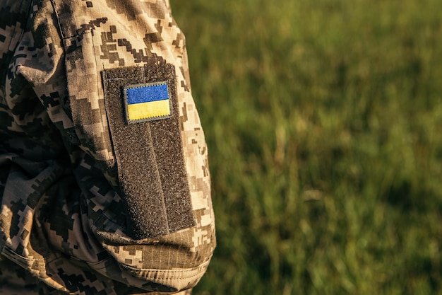 Close up velcro patch with flag of Ukraine on military uniform soldiers arm