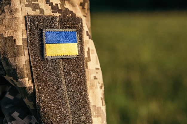 Close up velcro patch with flag of Ukraine on military uniform soldiers arm