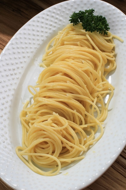 Close-up vers gekookte spaghetti, klaar om te serveren met saus. Concept van gezonde voeding. Op houten tafel