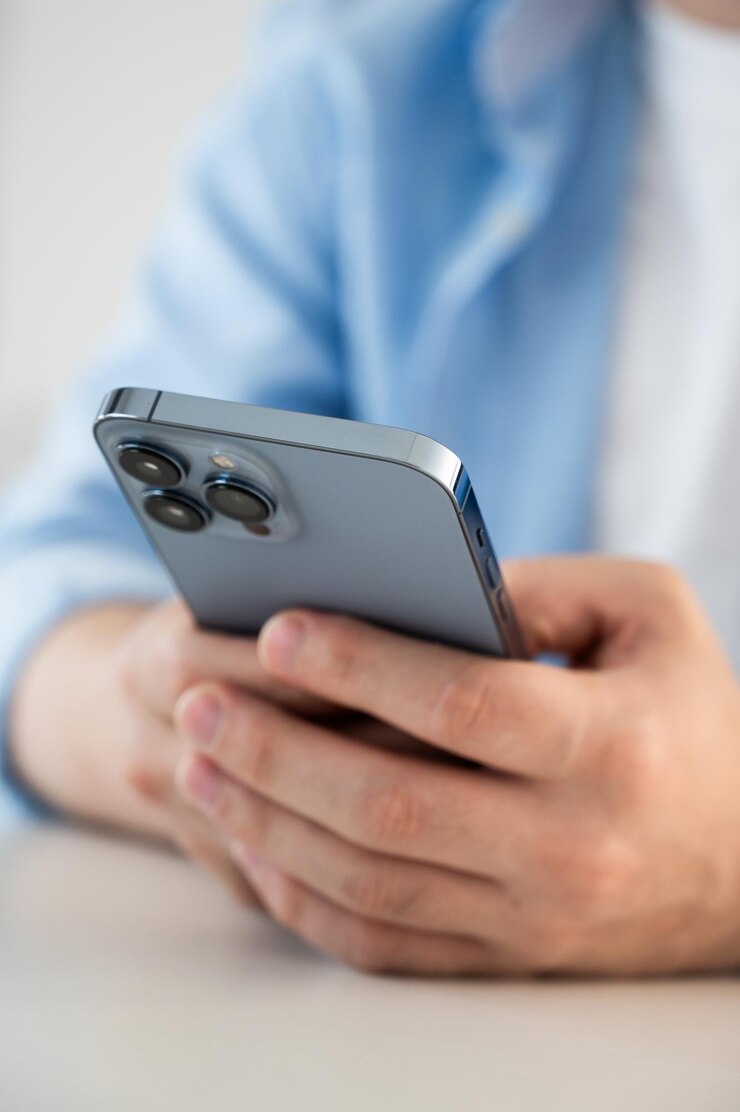 Photo close up vertical cropped view male hands holding smartphone seated at table spend time use edate services for singles mobile app usage young gen and modern wireless tech gadget overuse concept