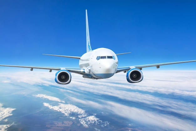 Close up view airplane in flight Passenger jet plane in the blue sky Aircraft flying high through clouds