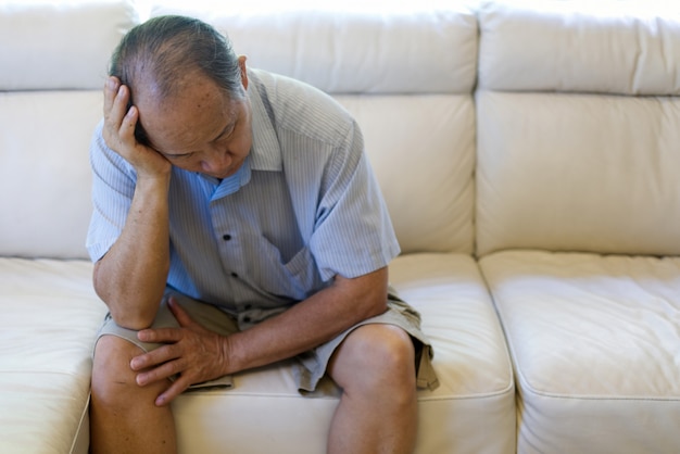 Close up view of Asian senior man suffering from headache.