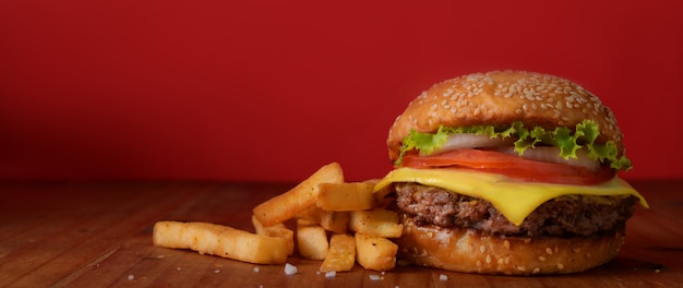 Close up view of beef burger and french fries on rustic table